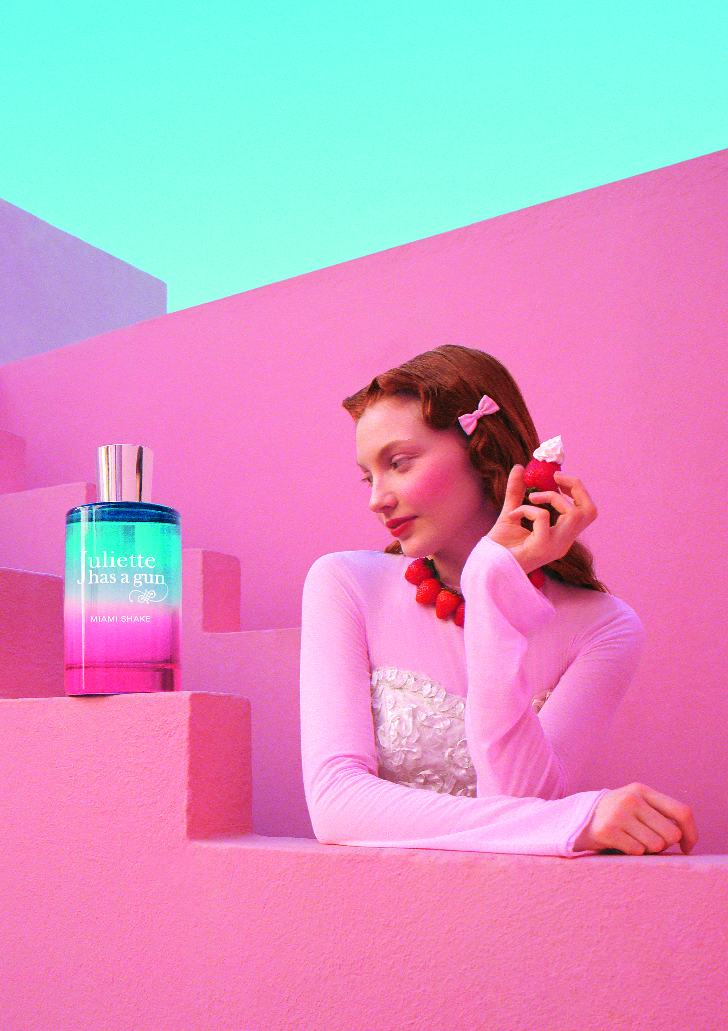 Interno di una villa rosa in stile retrò con piscina smeraldo, pattini a rotelle e dettagli pastello ispirati alla fragranza Miami Shake