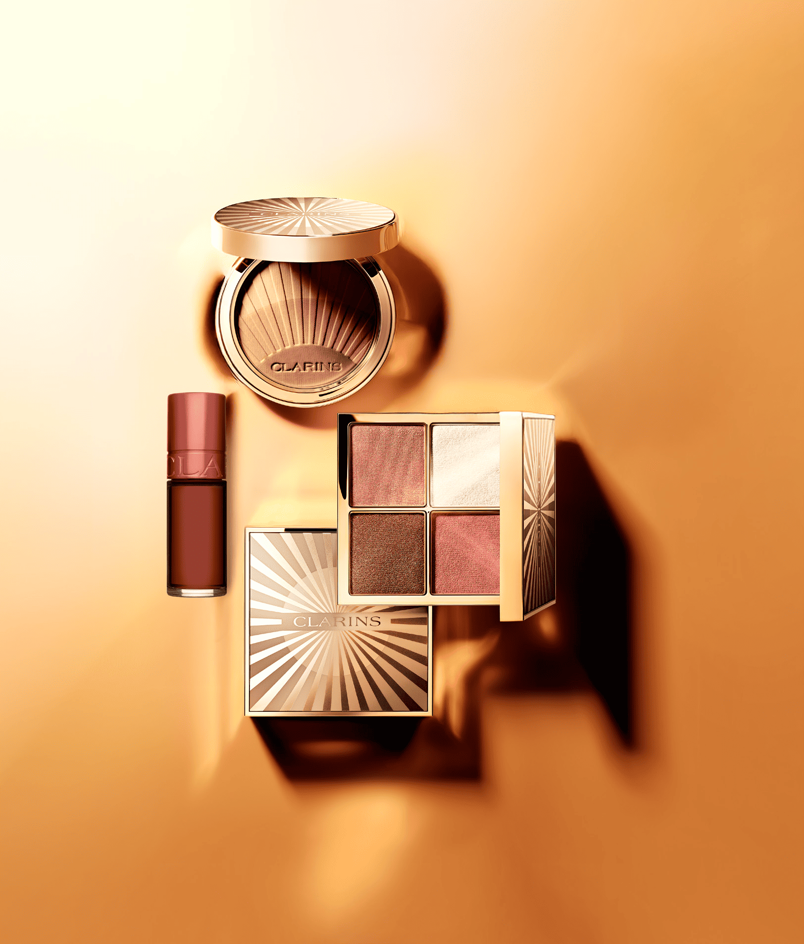 : Prodotti make-up Clarins collezione estate dorata con texture leggere, riflessi bronze e finish luminoso per un look estivo radioso