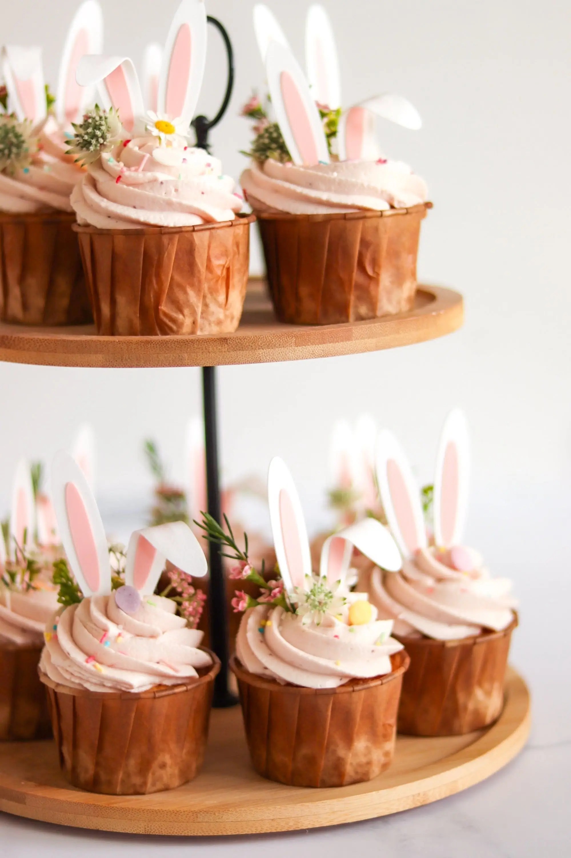 cupcake rosa con orecchie da coniglietto su alzatina per Pasquetta, dolci primaverili eleganti