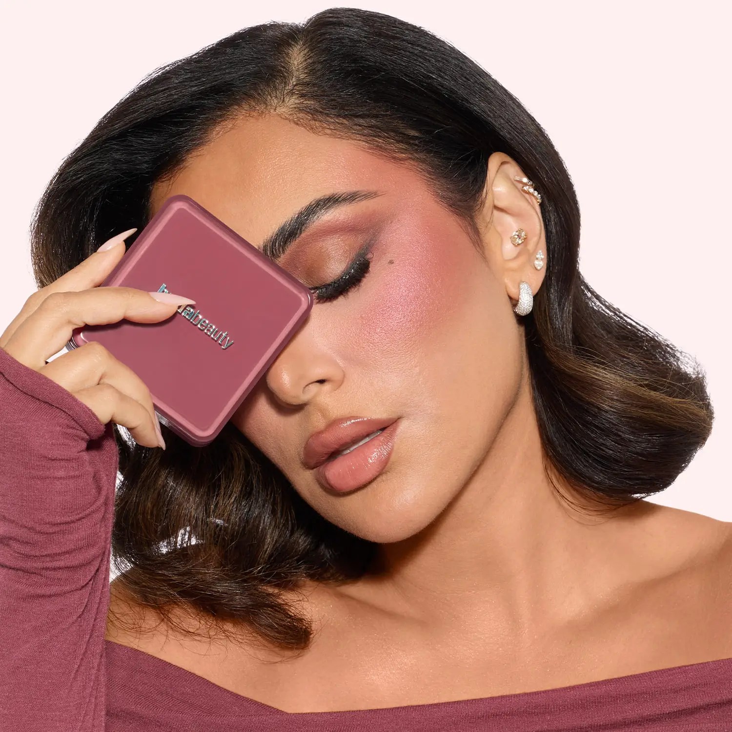 Huda Kattan, fondatrice di Huda Beauty, mentre indossa i prodotti della Strawberry Latte Collection